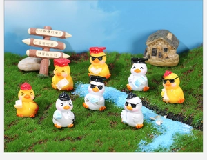 Miniature resin doctor duck figurines with glasses and hats on artificial lawn decor
