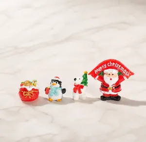 Detailed view of four resin Christmas figurines including Santa, polar bear, and penguin