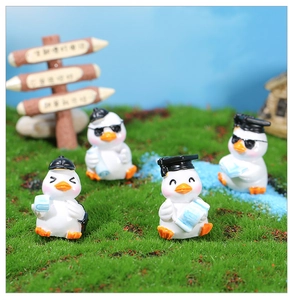 Macro shot of four creative resin duck figurines in a miniature garden landscape