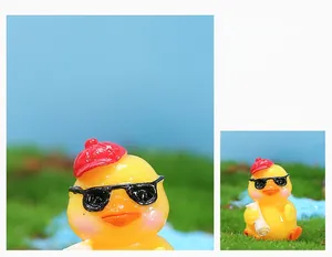 Macro detail of miniature yellow duckling figurine with red hat and sunglasses
