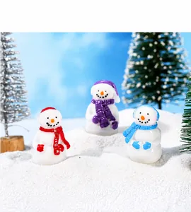 Detailed macro view of three miniature resin snowmen with colorful scarves for Christmas decor