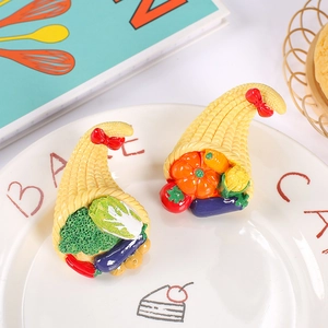 Miniature resin vegetable harvest horn magnets featuring broccoli and pumpkin in a ceramic dish
