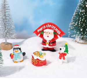 Detailed view of Christmas miniature resin figurines including Santa Claus and penguin on snow