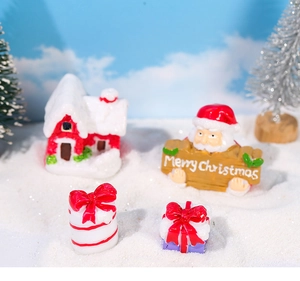 Detailed view of resin Santa figurine with snow cottage and gift box micro landscape