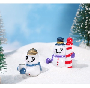 Detalle de dos figuras de muñecos de nieve de resina en un micro paisaje navideño nevado