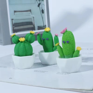 Three cute cartoon cactus figurines with heart eyes in white geometric pots for desk decor