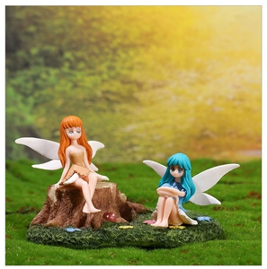 Detail of flower fairy figurines with translucent wings on a mossy stump base