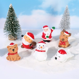 Set de miniaturas navideñas con Papá Noel, reno y muñeco de nieve sobre nieve falsa