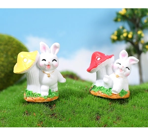 Gros plan de lapins miniatures en résine avec champignons sur socle d'herbe verte