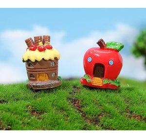 Detailed view of miniature resin house ornaments in cupcake and red apple designs