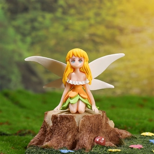 Whimsical flower fairy figurine with white wings sitting on a wood base with mushrooms