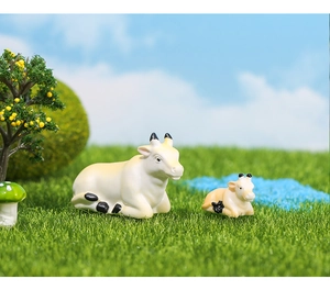Macro shot of miniature resin cow figurines in a garden landscape for DIY bonsai decor