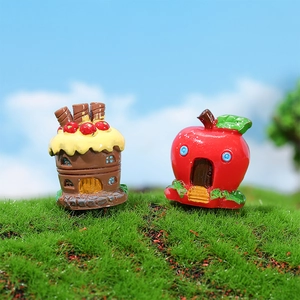 Miniature resin fairy garden houses featuring a cake cottage and red apple home on grass