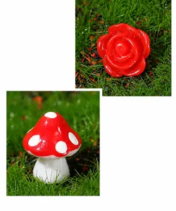 Close-up of resin red rose and spotted mushroom miniature ornaments for fairy garden