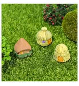 Close-up of detailed resin miniature thatched houses for moss landscape garden decor