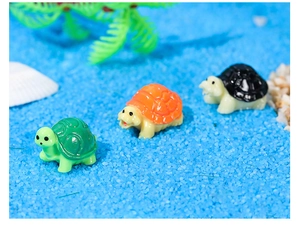 Tre tartarughe in miniatura in resina colorata su sabbia blu per paesaggi di muschio fai da te