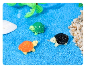 Vista dettagliata di tre figurine di tartaruga in resina colorata in un paesaggio marino