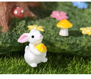Gros plan d'une figurine de lapin blanc en résine tenant un champignon jaune pour micro paysage
