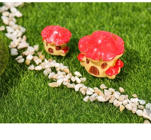 Macro view of two red resin mushroom house figurines for miniature garden decor