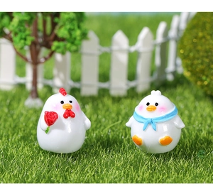 Detailopname van schattige miniatuur kuikens van hars in een mos tuinlandschap