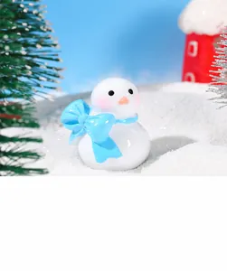 Primer plano de una figura de muñeco de nieve con lazo azul en una escena invernal