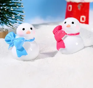 Detalle macro de figuras de muñecos de nieve con lazos en una escena de nieve navideña