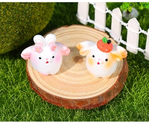 Detail showing cute resin rabbit figurines with strawberry and pink flower accessories