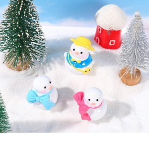 Detailweergave van drie schattige sneeuwpopfiguren van hars in een winters sneeuwlandschap
