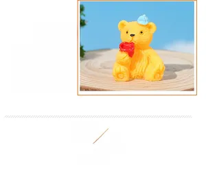Detailansicht der handgefertigten Teddybär-Figur aus Harz mit blauem Hut und rotem Herz