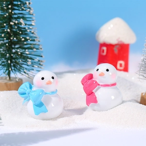 Schattige miniatuur sneeuwpopfiguren met blauwe en roze strikken voor winter micro landschap