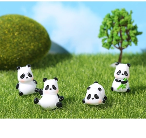 Detail showing four miniature resin pandas in various poses on a scenic lawn background