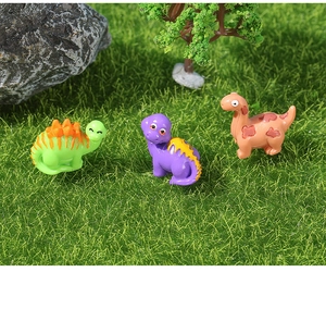 Drie kleurrijke miniatuur dino's van hars op gras voor micro-landschap decoratie