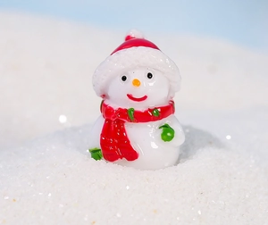 Detailansicht der Mini-Schneemann-Figur für Weihnachtslandschaften mit roter Mütze und Schal