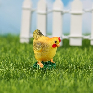 Miniature resin yellow chick figurine with feather texture on a green grass base