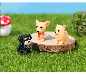 Detailed view of resin puppy figurines including Schnauzer and Pomeranian on faux grass