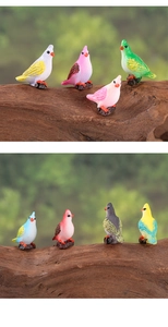 Miniature colorful parrot figurines on tree stumps for succulent fairy garden decor