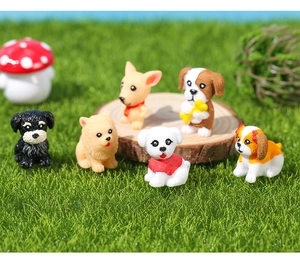 Close-up of miniature resin puppy figurines and a mushroom on a natural wood slice
