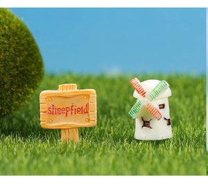 Miniature garden sheepfield sign and colorful windmill resin ornaments on grass