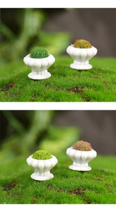 Macro shot of miniature white embossed flower pots with colorful moss plants for dollhouses
