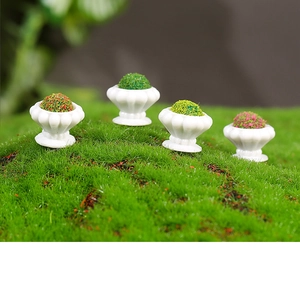 Detailed macro view of four miniature pumpkin-shaped flower pots with colorful moss