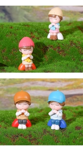 Close-up of four cute miniature praying couple figurines for moss micro landscape decor