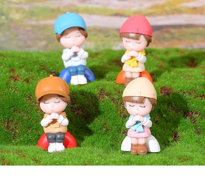 Set of four cute miniature praying figures on green moss for micro landscape decor