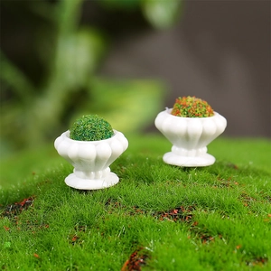 Miniature flower bed dollhouse model with two white striped pots on green moss