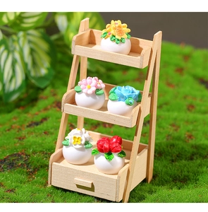 Miniature dollhouse flower pots set with colorful plants on a three-tier wooden display stand