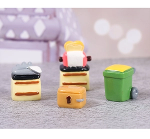 Detailed macro view of miniature dollhouse red toaster, cabinets and tiny green trash bin