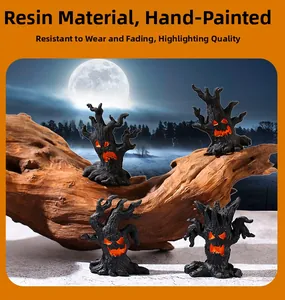 Detail view of four resin Halloween ghost tree figurines with hand-painted glowing faces