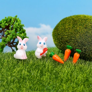 Miniature resin white rabbit figurines with carrots set on artificial green grass