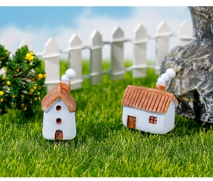 Casas en miniatura de resina con techos rojos en una pequeña escena de jardín decorativa