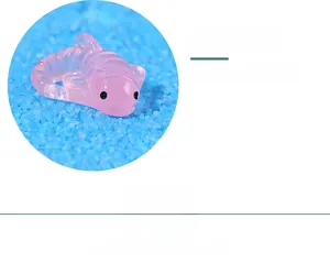 Close-up of pink translucent resin axolotl miniature for aquarium decor on blue sand