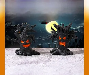 Detail of two resin Halloween monster tree ornaments with glowing orange faces